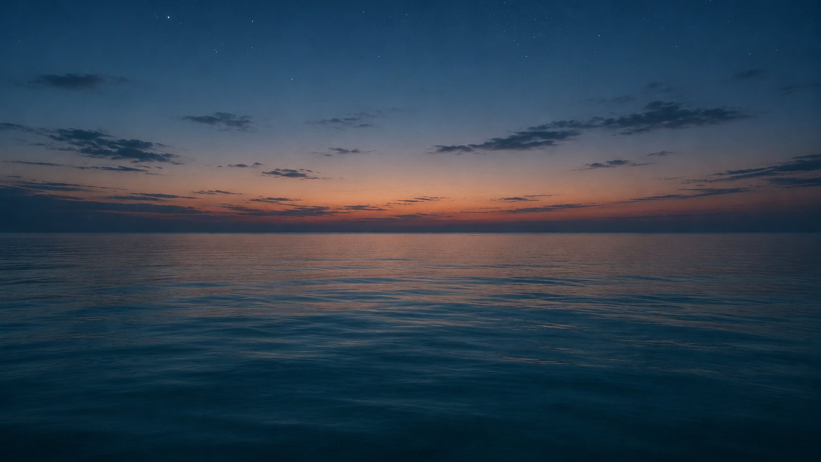 A calm sea at dusk under the first stars