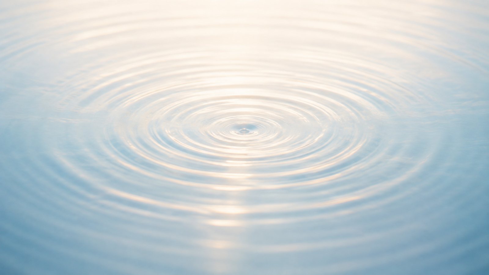Concentric ripples spreading across pale water